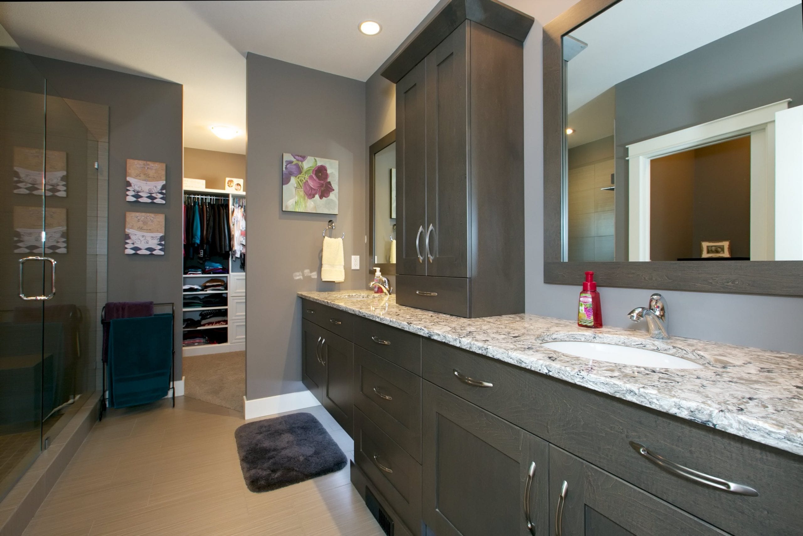 interior shot of westharbour home master bathroom with a his and hers sink assorted cabinetry and a walk in closet