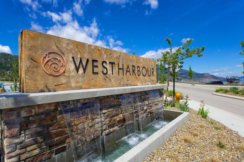 west harbour sign with little fountain streaming from it and okanagan lake in background