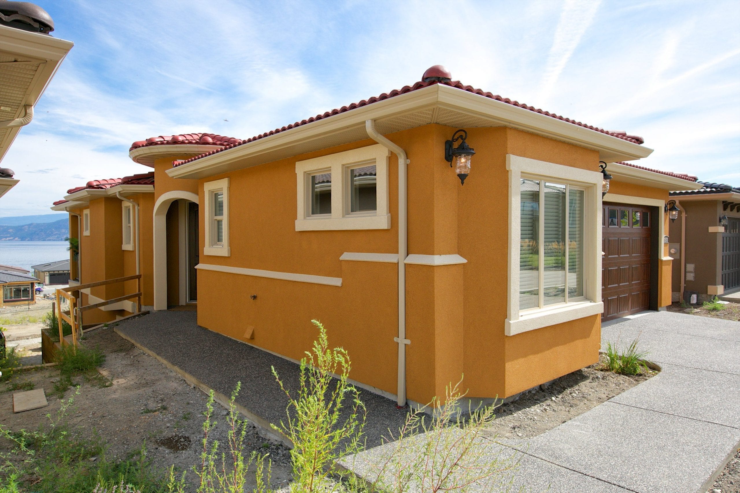 sideways facing exterior shot of butterscotch coloured west harbour home with a red roof