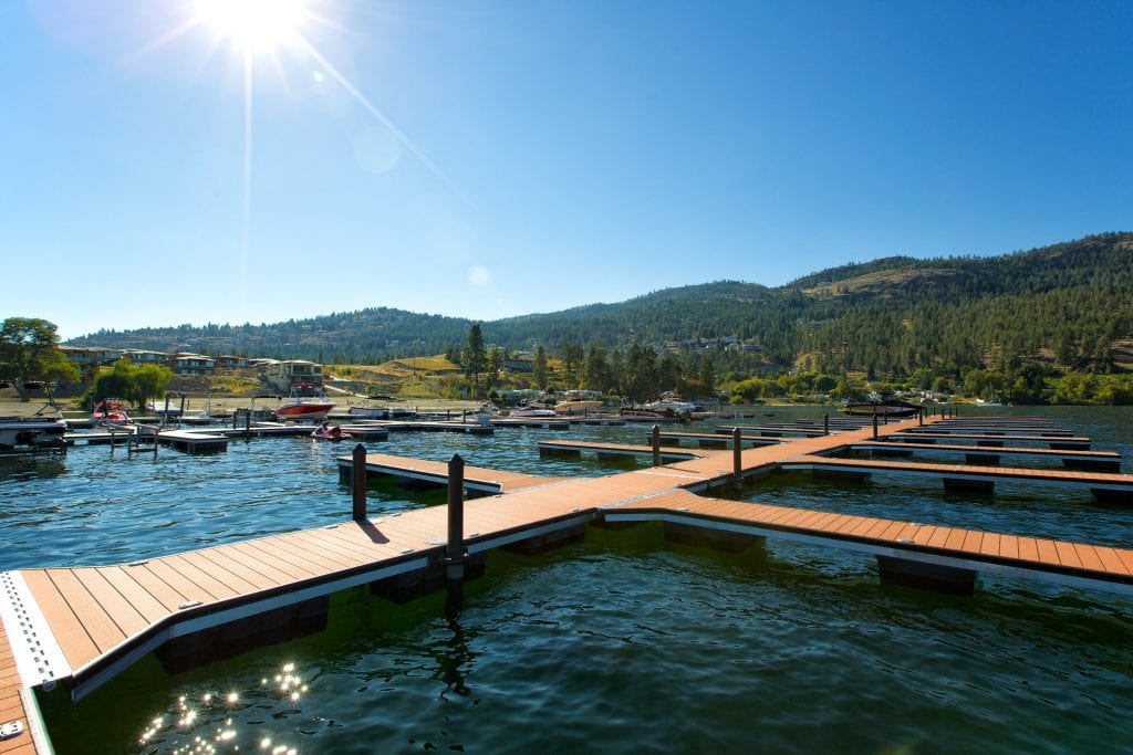 marina shot of a clear beautiful day with the mountains the sun and the docked boats in the distance