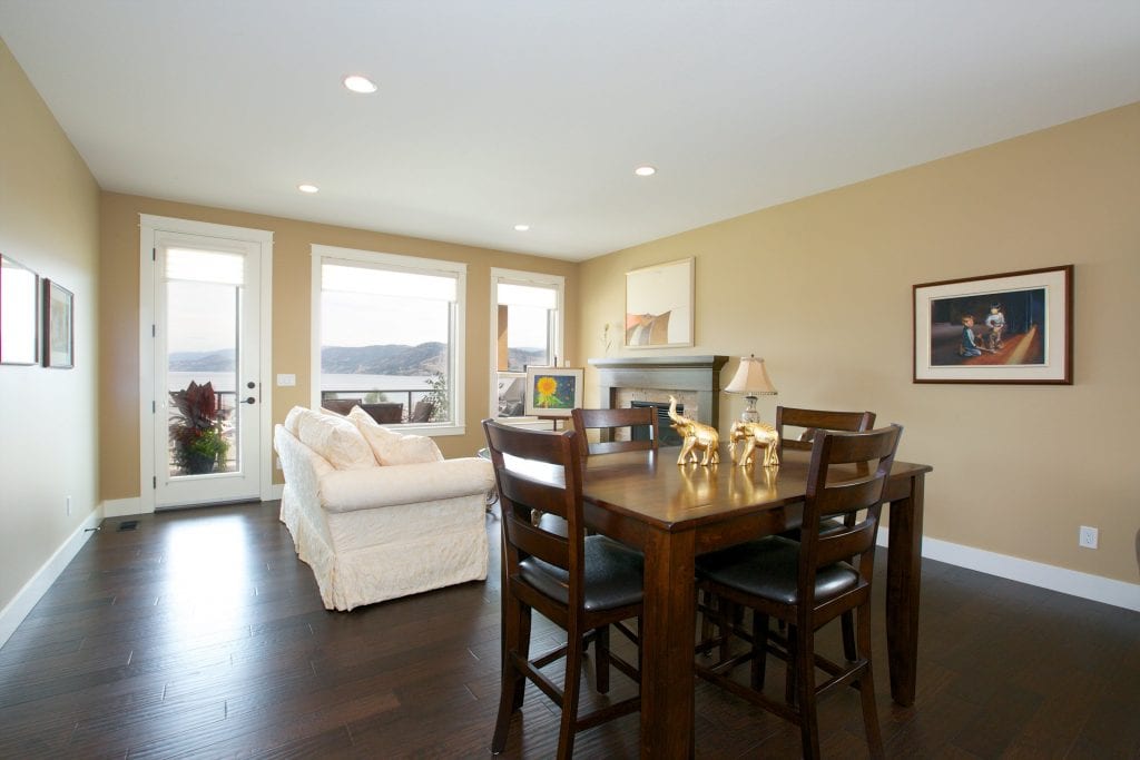 interior shot of west harbour home dining area and living space with mohogany chairs and table alongside a white couch