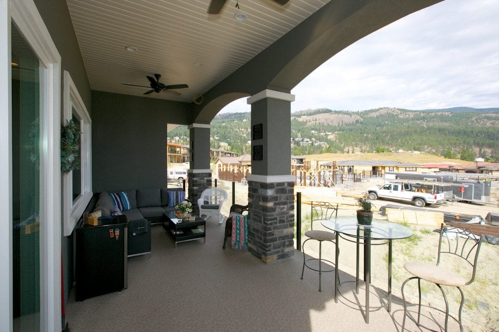 patio shot of west harbour home looking out at the mountains and with multiple different kinds of chairs and tables