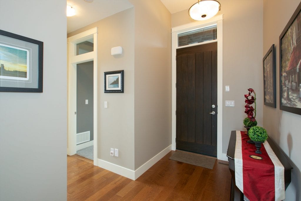 interior shot of west harbour doorway featuring lit lights multiple houseplants on a table and several framed pictures