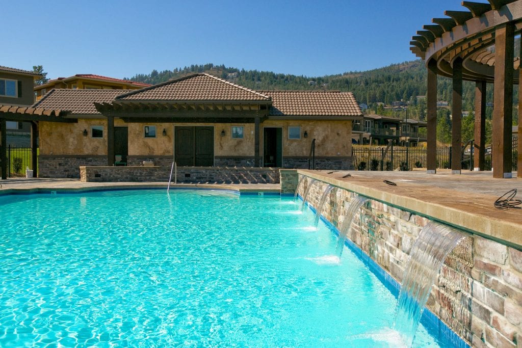 luxury mediterranean style pool with house in full view